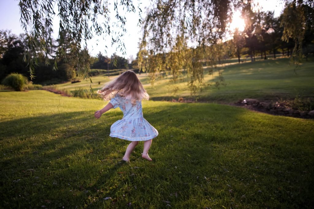 little girl whirling on lawn